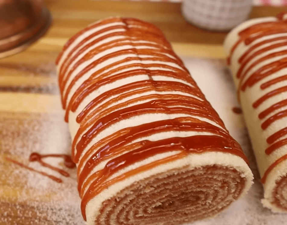 A close up of a sliced authentic Brazilian Bolo de Rolo showing the many thin layers of cake and guava swirl.