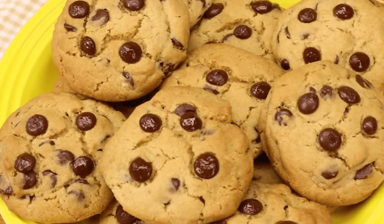 A stack of freshly baked, thick chocolate chip cookies with melted chocolate chunks on top, resting on a wire cooling rack to showcase this easy chocolate chip cookie recipe.