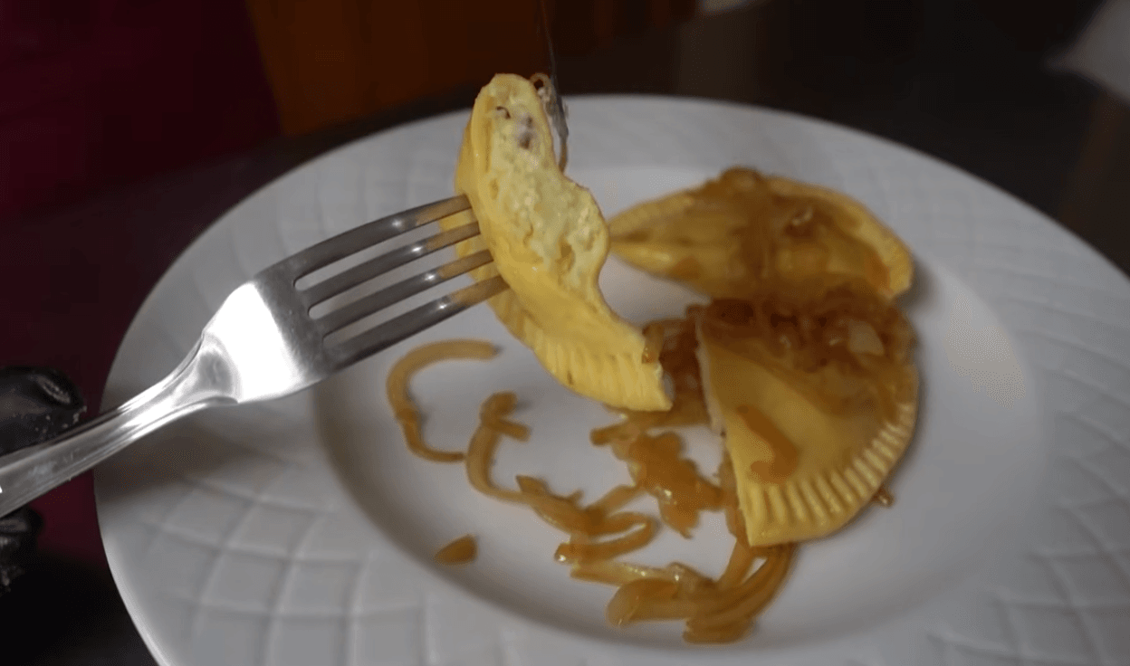 Traditional Polish pierogi filled with potato and cheese topped with caramelized onions